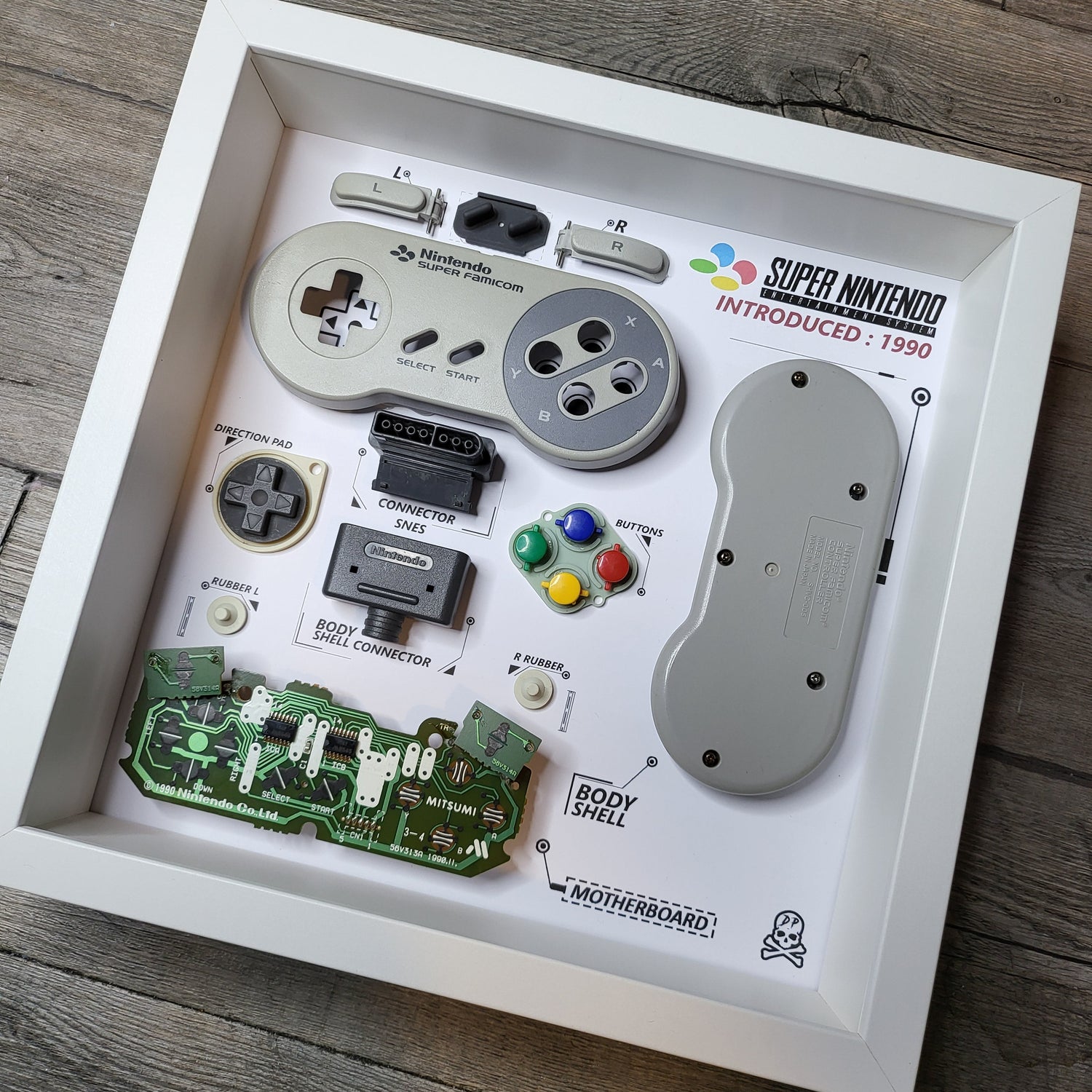 Shadow Box 10x10 with wood frame and polycarbonate glass for wall and Tabletop containing a disassembled controller for Playstation and Nintendo