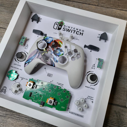 Shadow Box 10x10 with wood frame and polycarbonate glass for wall and Tabletop containing a disassembled controller for Playstation and Nintendo