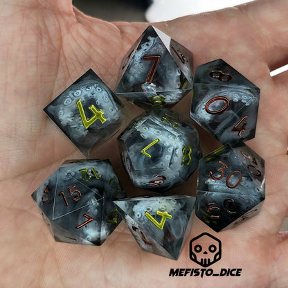 Black and gray resin DnD dice set with detailed tentacle patterns inside and metallic red and yellow numbers