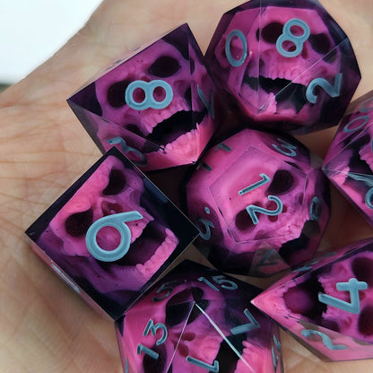 Close-up of black resin dice with pink undead zombie skulls and grey numbers, handcrafted by Mefisto_Dice.