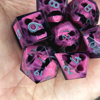 Close-up of black resin dice with pink undead zombie skulls and grey numbers, handcrafted by Mefisto_Dice.