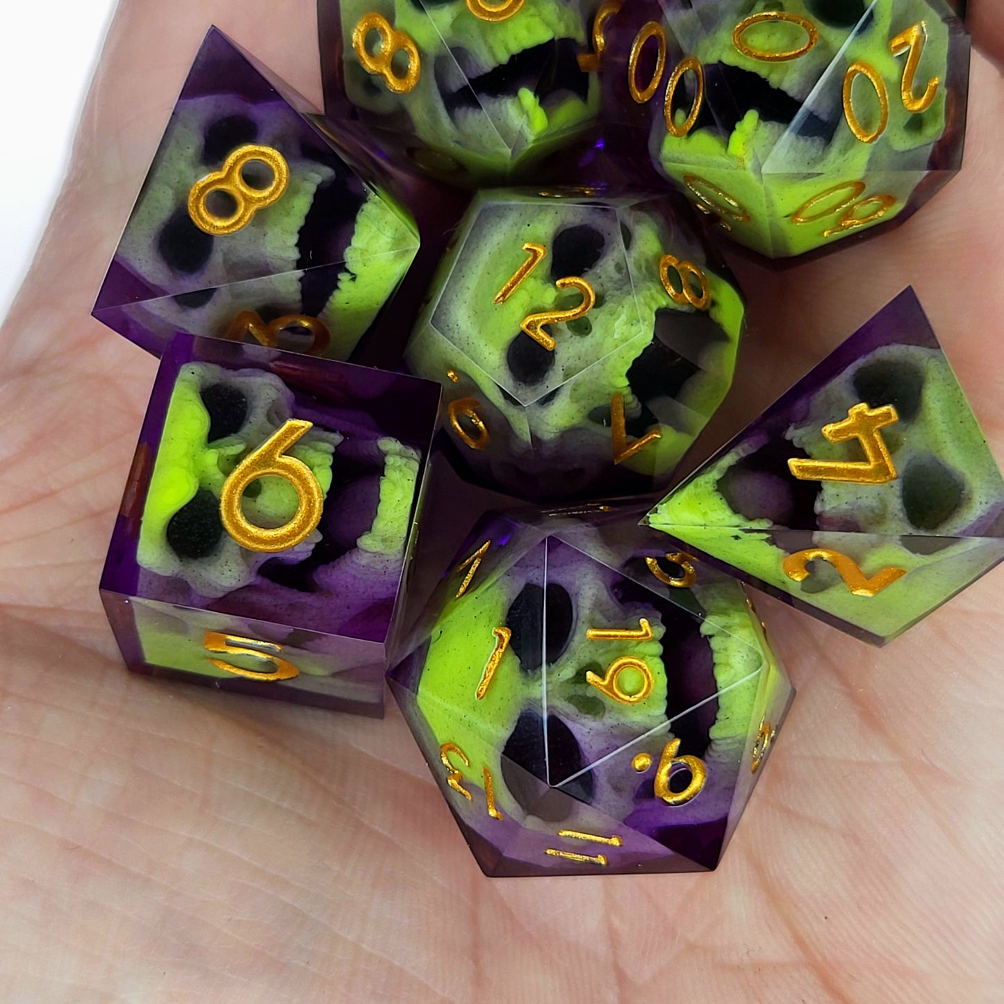 Close-up of purple resin dice with acid-green undead zombie skulls and gold numbers, handcrafted by Mefisto_Dice