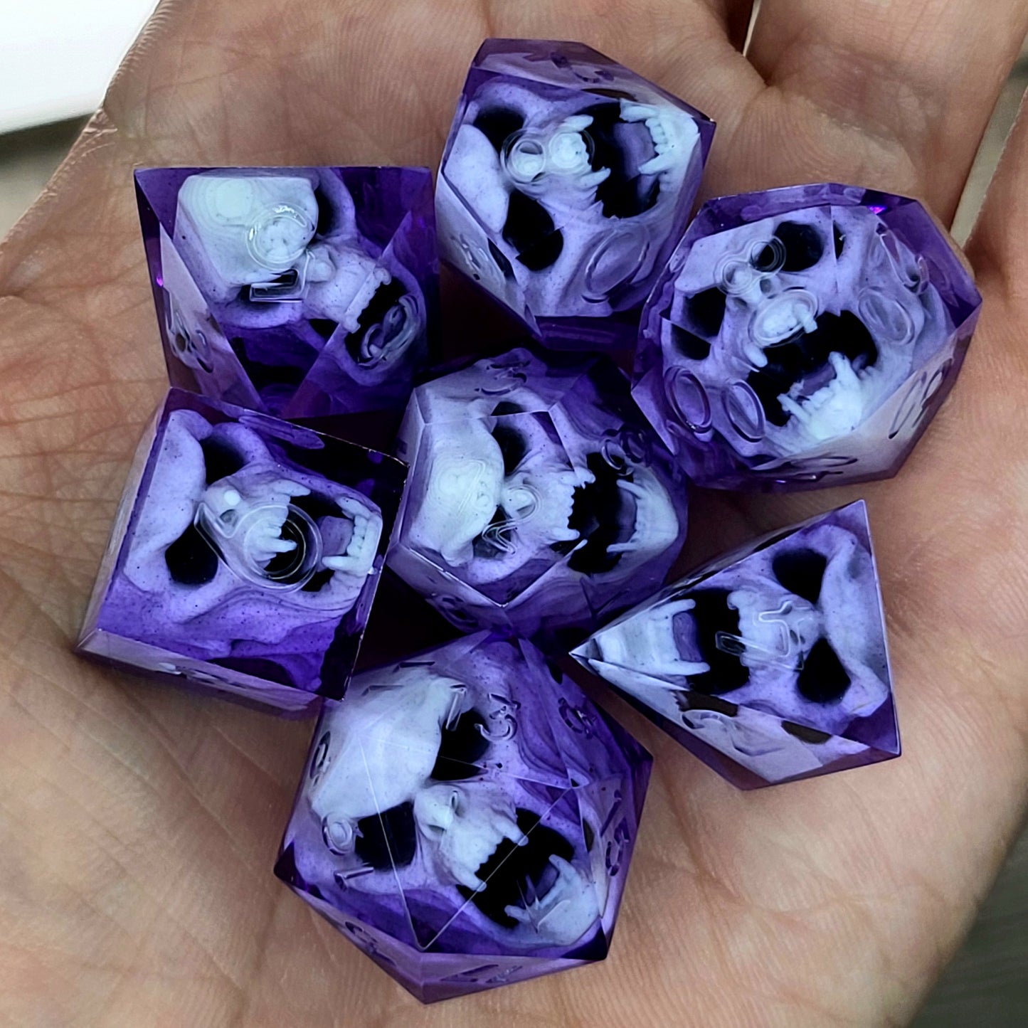 Purple resin DnD dice set with detailed white vampire skulls inside