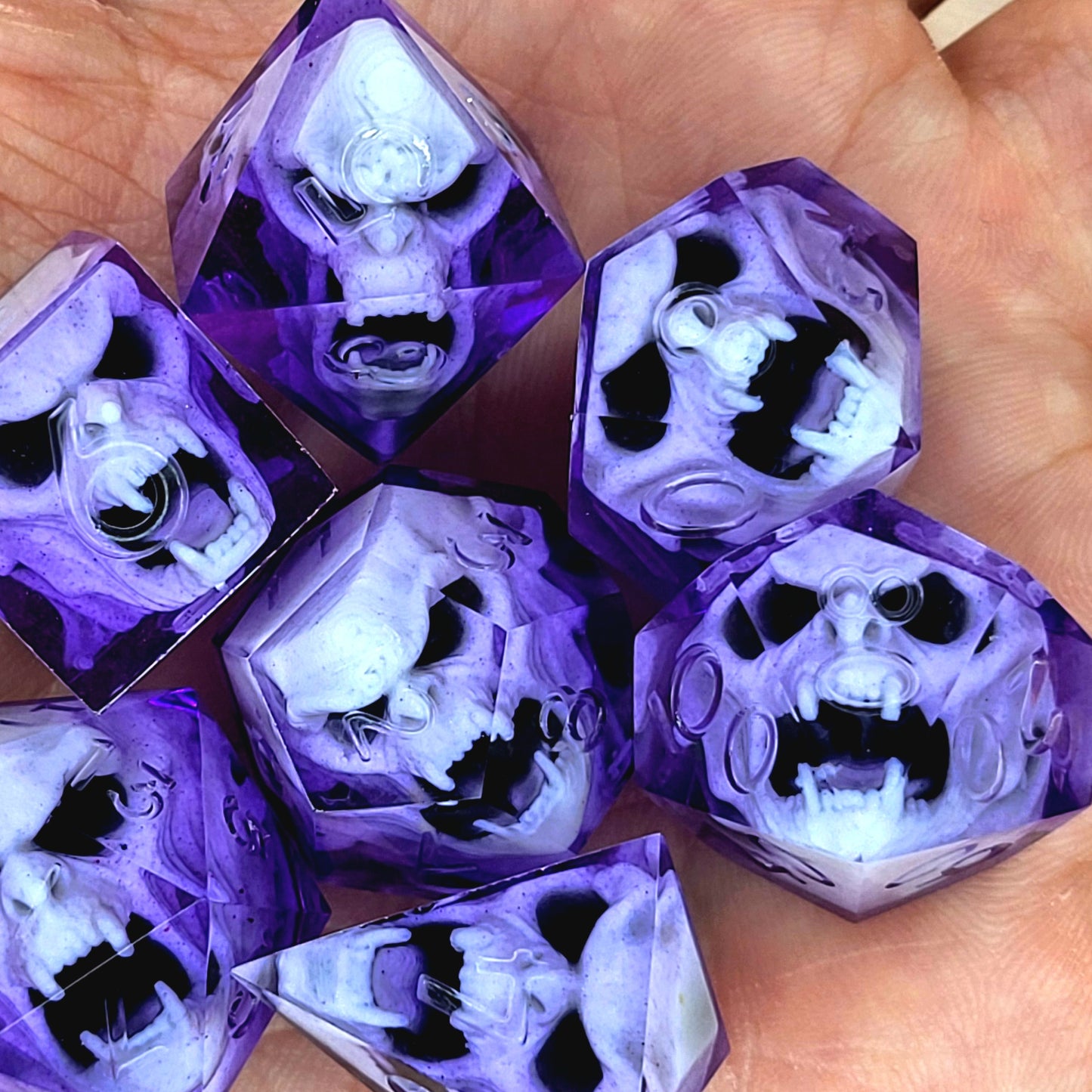 Purple resin DnD dice set with detailed white vampire skulls inside