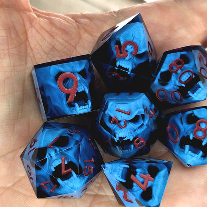 Blue resin DnD dice set with light blue skulls inside and red engraved numbers