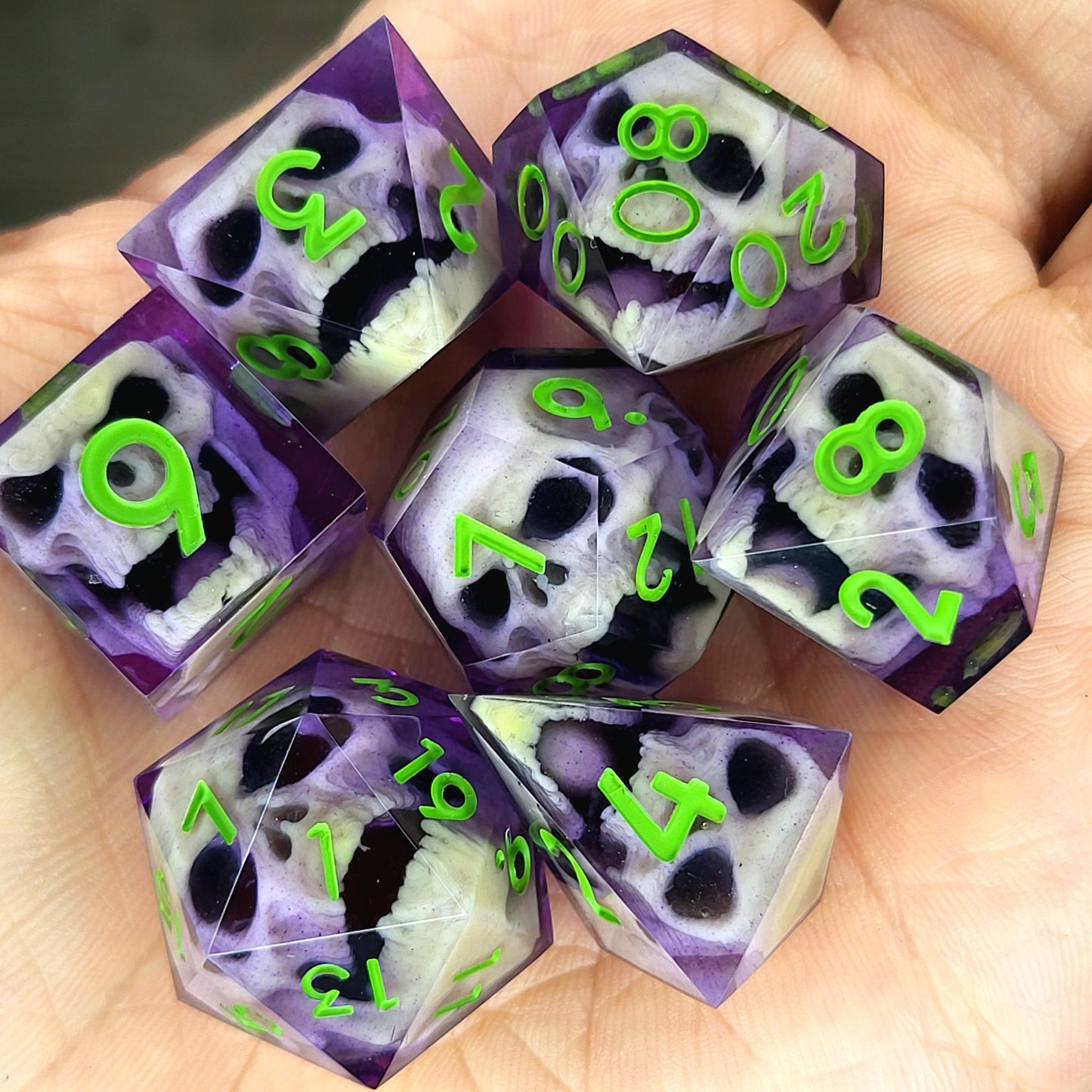 Purple resin DnD dice set with bone-colored zombie skulls inside and bright green numbers