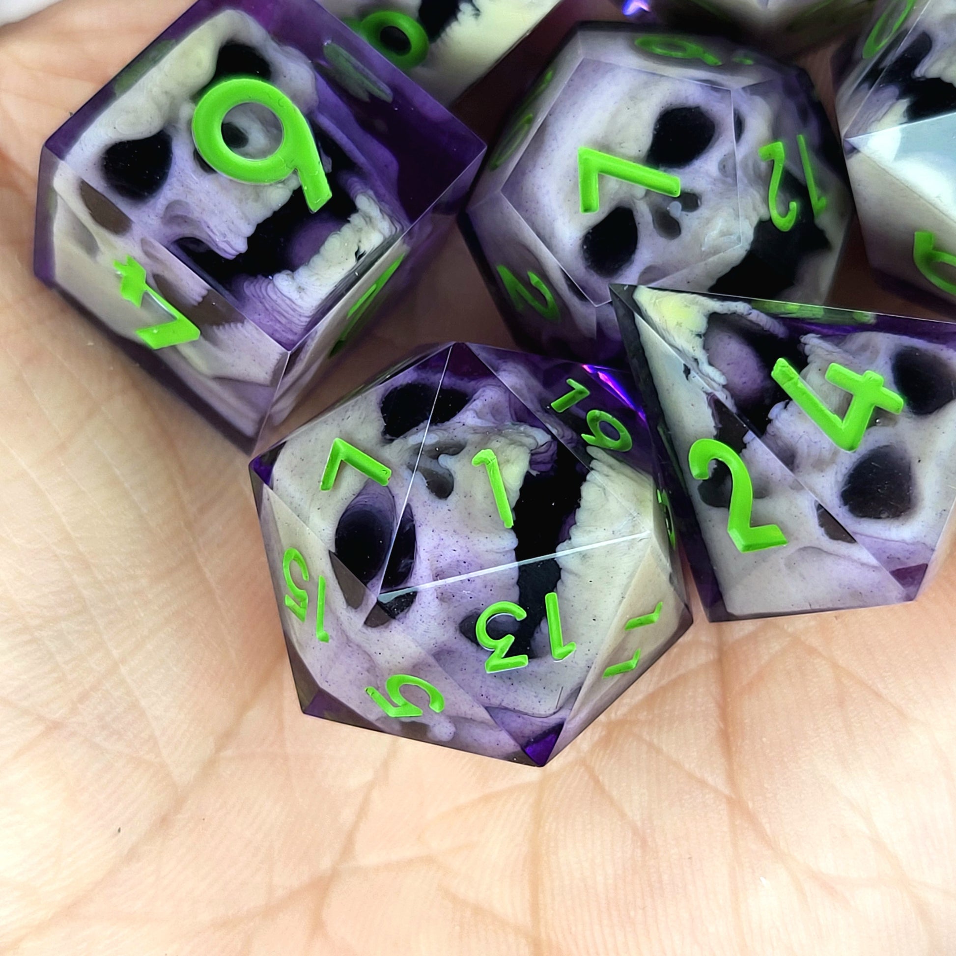 Purple resin DnD dice set with bone-colored zombie skulls inside and bright green numbers