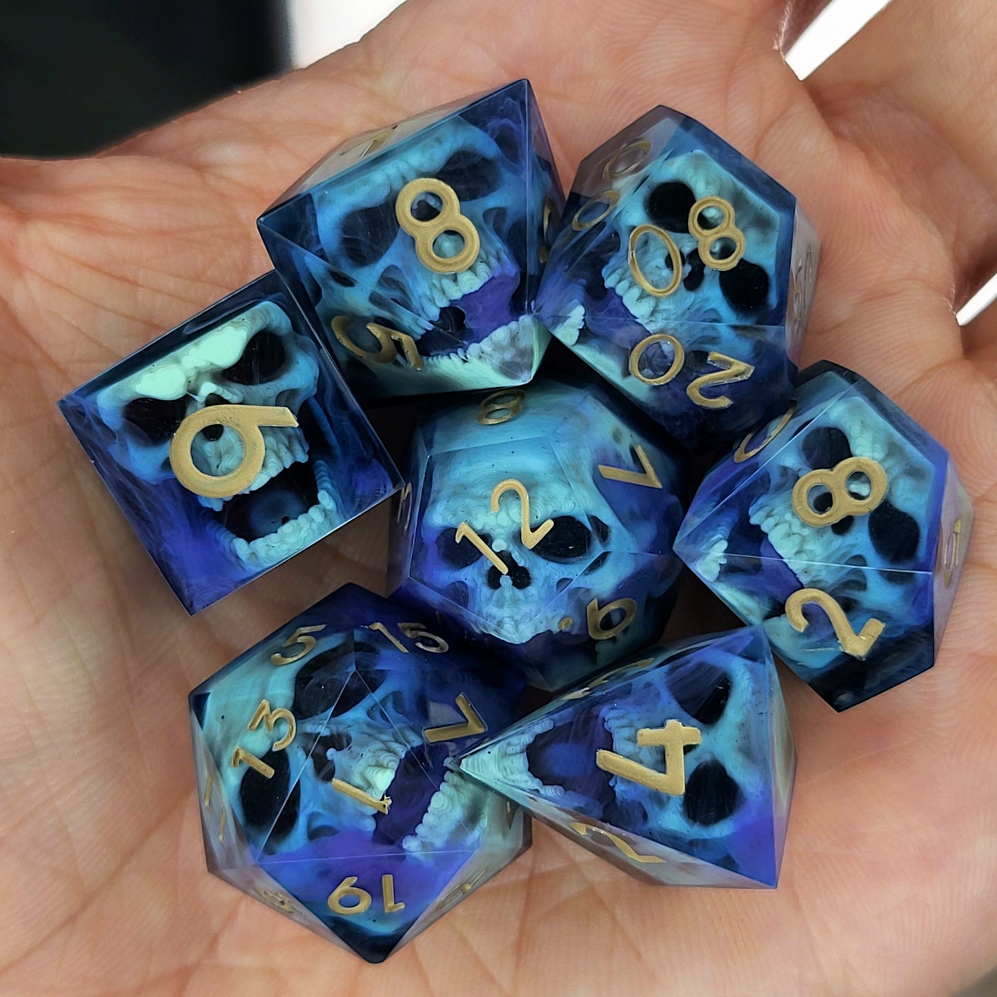 Black resin dice set with light green undead skulls, purple smoky swirls and gold numbers, handcrafted RPG dice for DnD and fantasy tabletop games