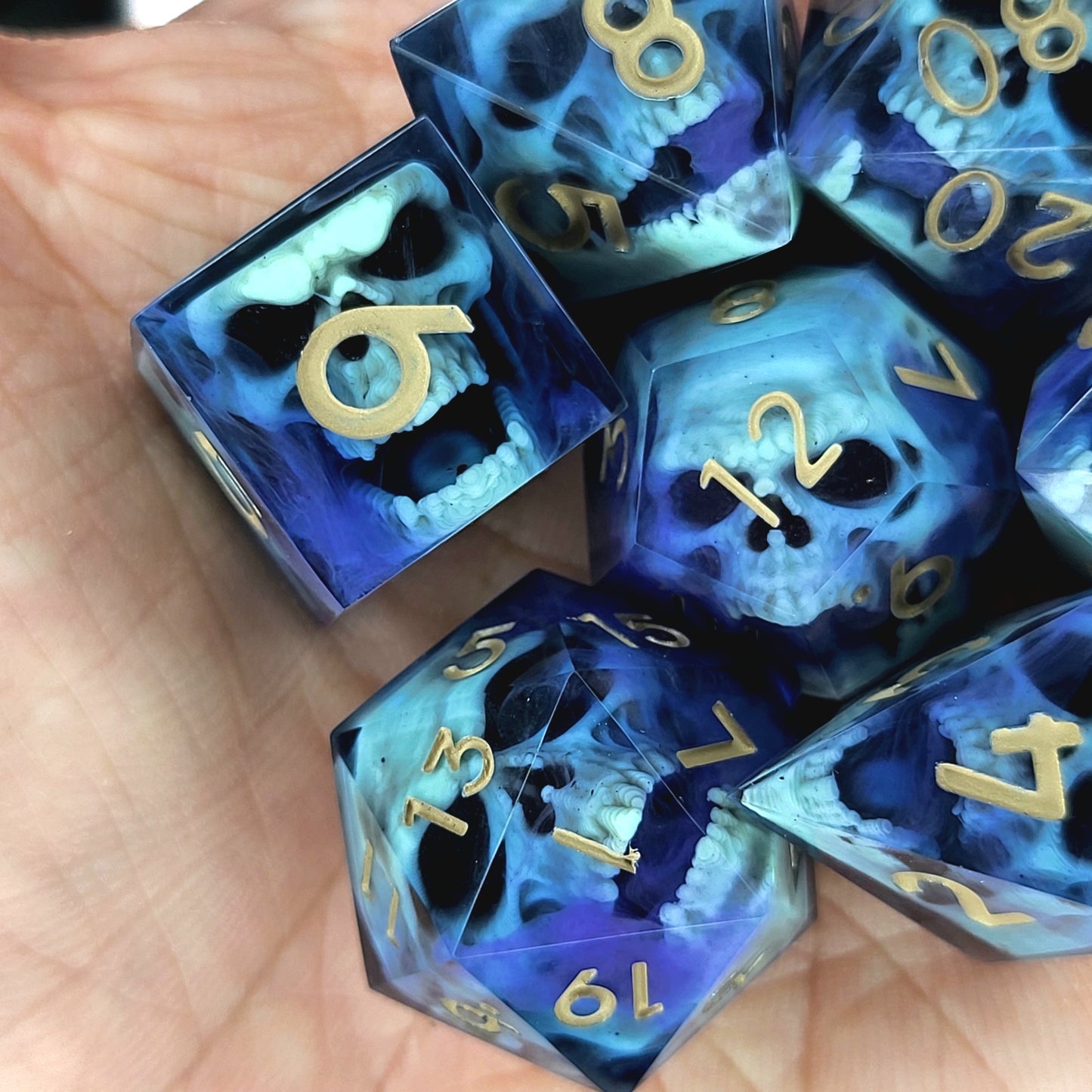 Black resin dice set with light green undead skulls, purple smoky swirls and gold numbers, handcrafted RPG dice for DnD and fantasy tabletop games