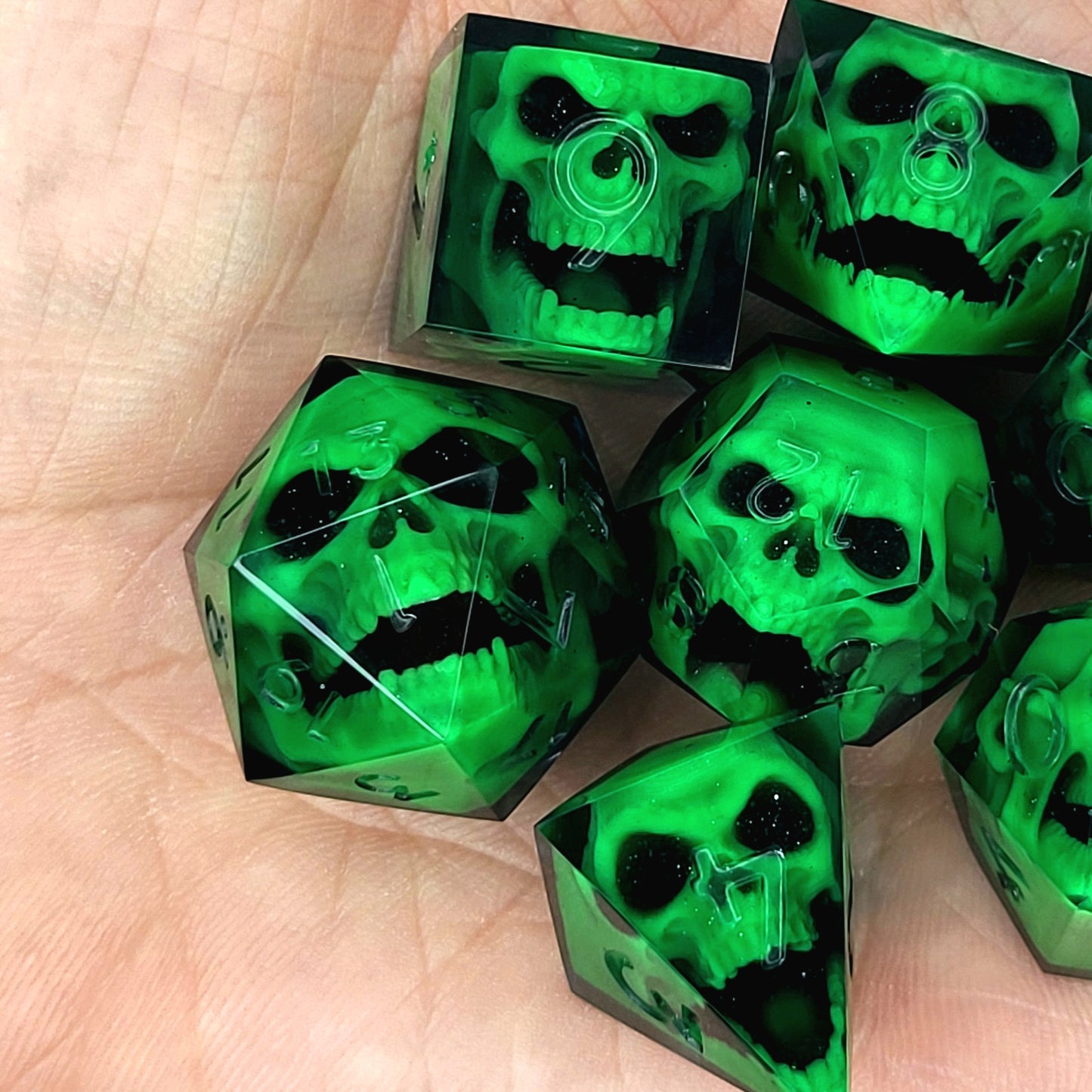 Black resin DnD dice set with bright green zombie skulls inside