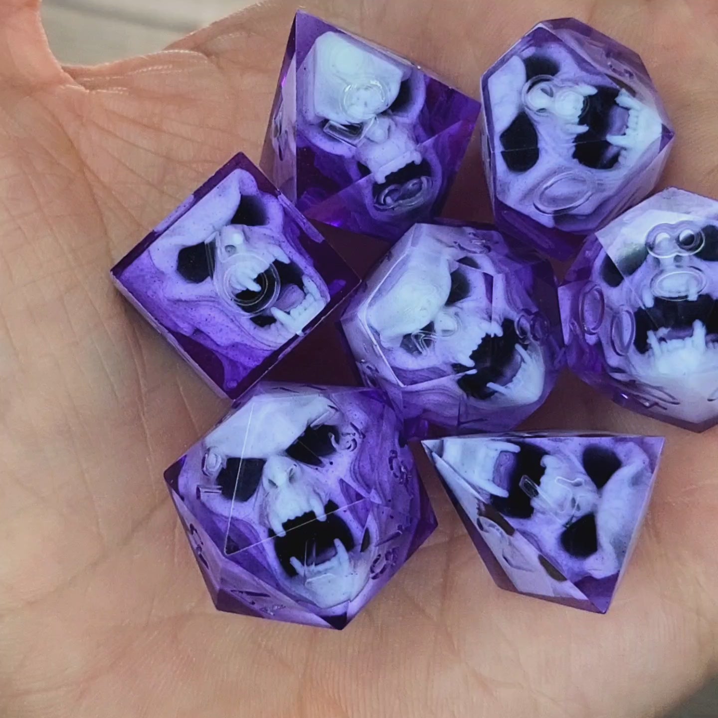 Purple resin DnD dice set with detailed white vampire skulls inside