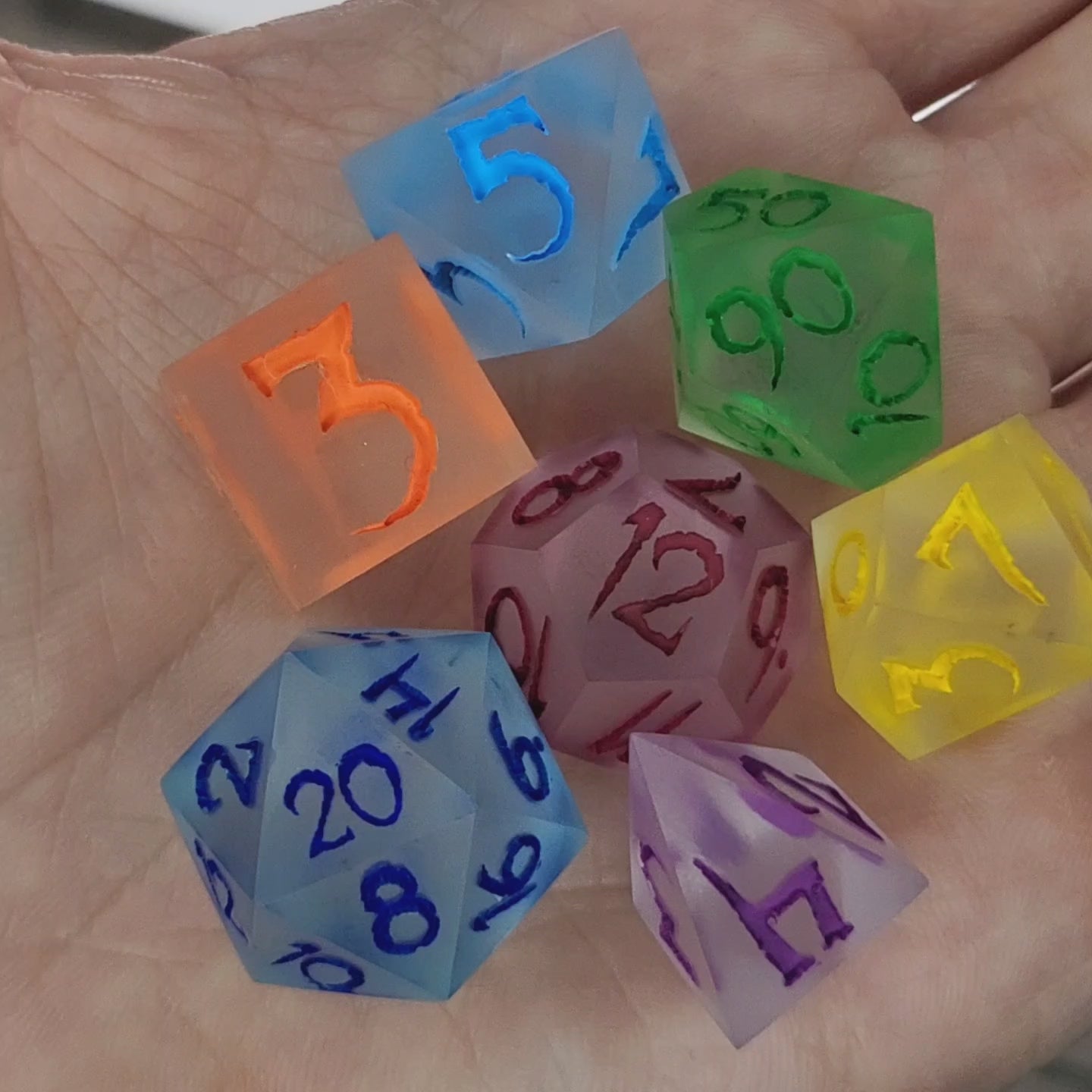 Multicolor frosted resin DnD dice set with matte finish in blue, green, yellow, orange, purple, and red tones
