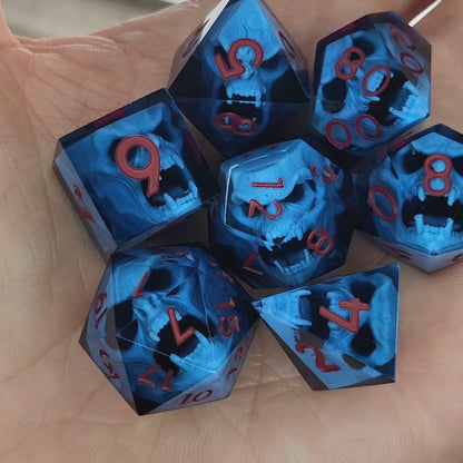Blue resin DnD dice set with light blue skulls inside and red engraved numbers