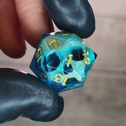 This is a single set of one D20 DnD die with a light brown skull inside , blue resin and gold numbers