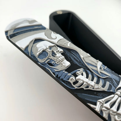 Close-up of a dice box featuring a detailed skeleton reaper illustration in shades of grey and blue, designed for storing RPG dice, handcrafted by Mefisto_Dice.
