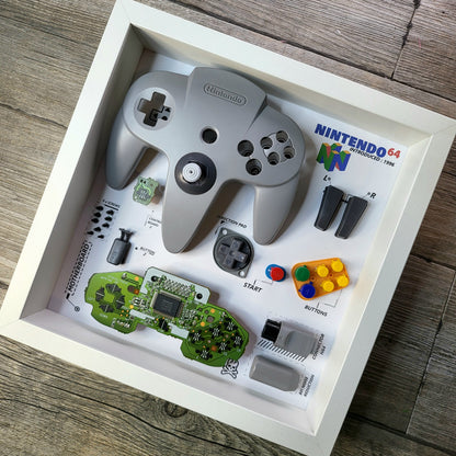Shadow Box 10x10 with wood frame and polycarbonate glass for wall and Tabletop containing a disassembled controller for Playstation and Nintendo