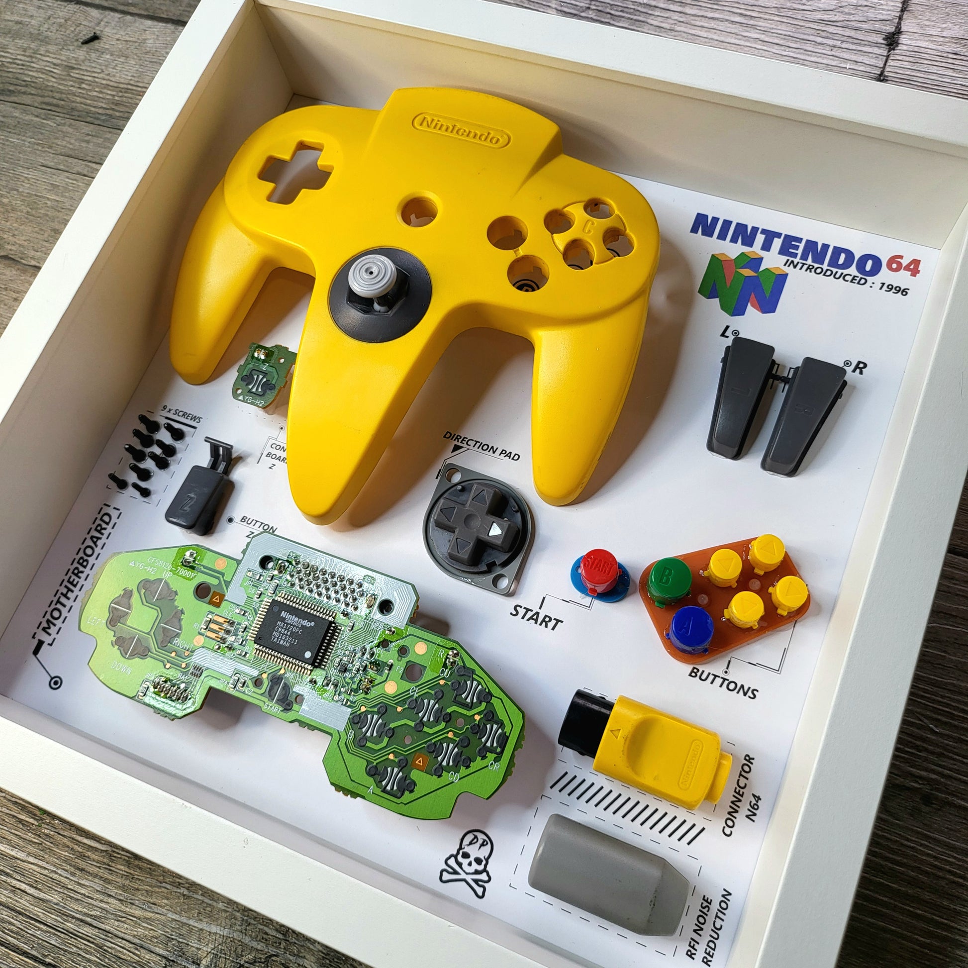 Shadow Box 10x10 with wood frame and polycarbonate glass for wall and Tabletop containing a disassembled controller for Playstation and Nintendo